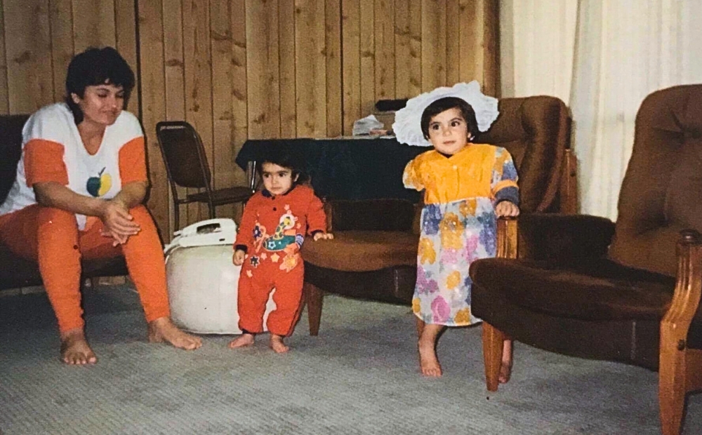 NOURI, aged 3, stands in her living room with her mother and younger sister in their first home in New Zealand. 