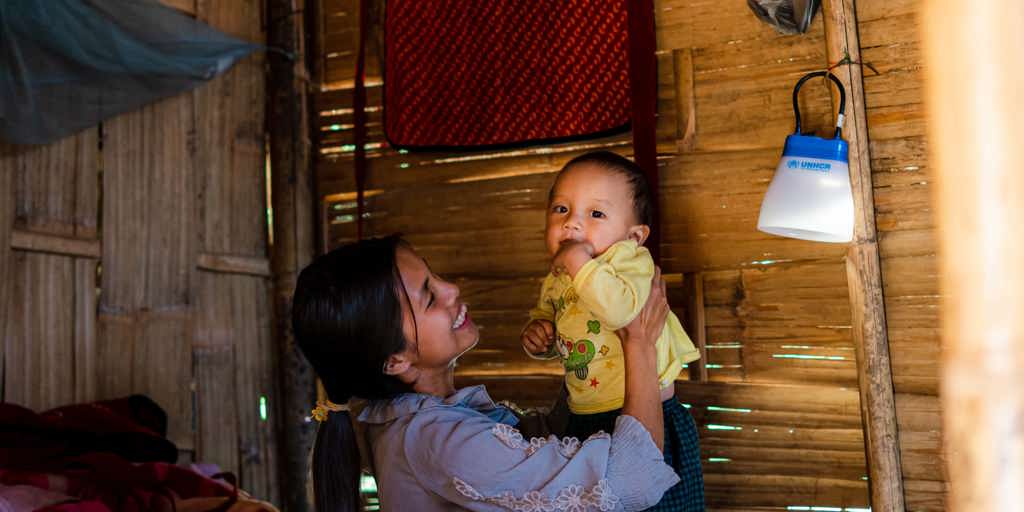 A displaced woman plays with her baby in their shelter. Myanmar faces overlapping crises, with around 3.5 million people displaced inside the country.
