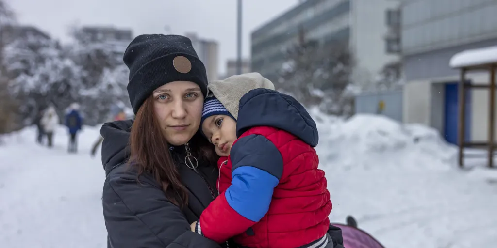 Woman holds child in the snow. Kateryna fled her hometown of Kryvyi Rih in southern Ukraine on 6 March.