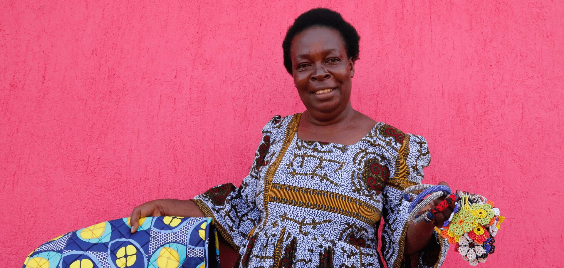 Gloria, a Congolese refugee in Uganda, shows off her brightly coloured handicrafts
