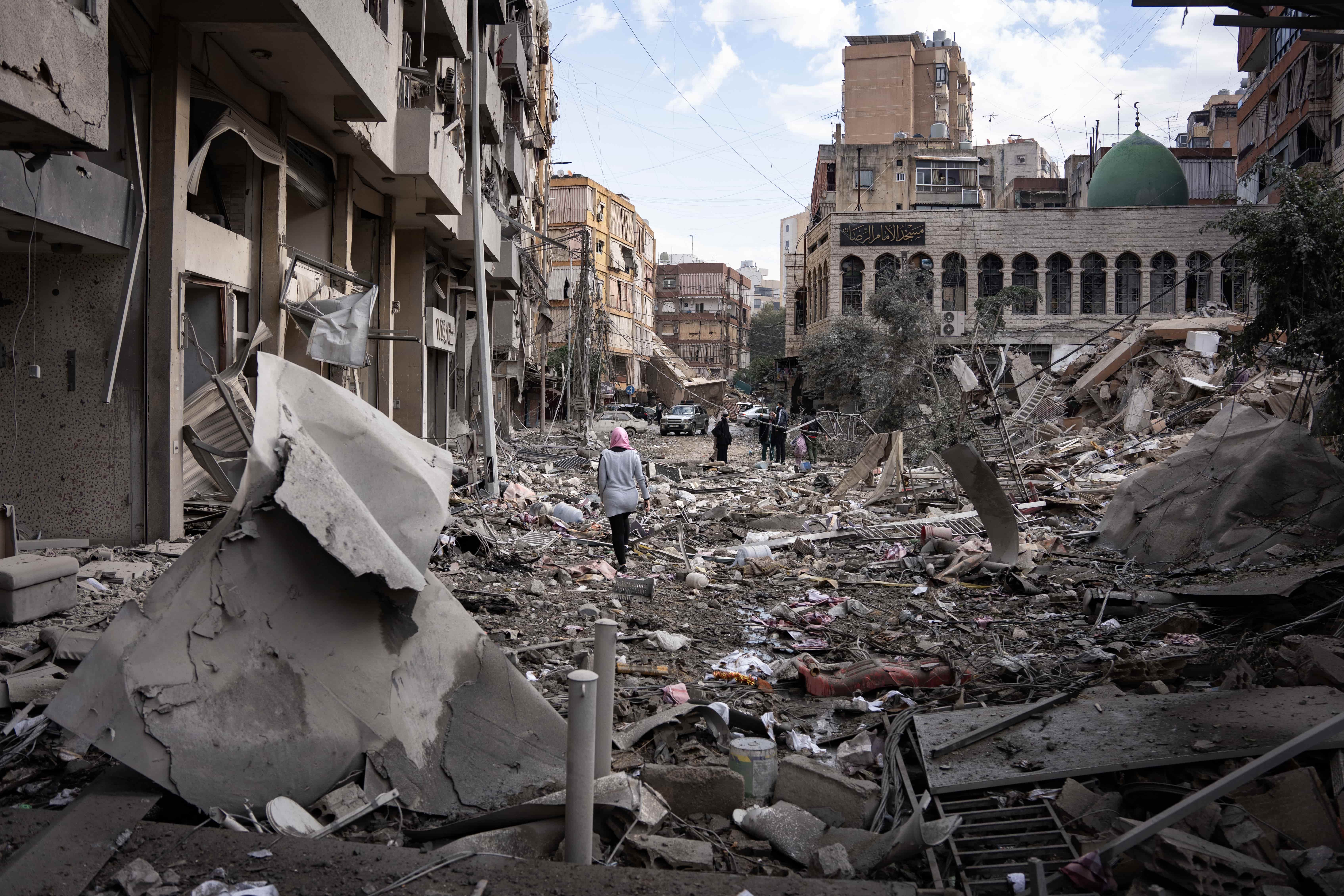 A woman walks over the rubble of a bombed building in the southern Beirut suburb of Dahiye.