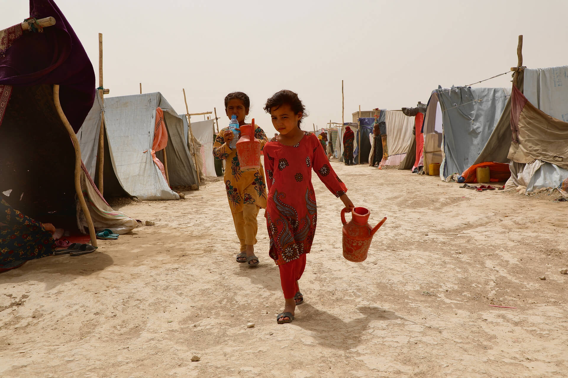 Children on their way out of the Nawabad Farabi-ha IDP camp as the wind and the dust blows though the camp.