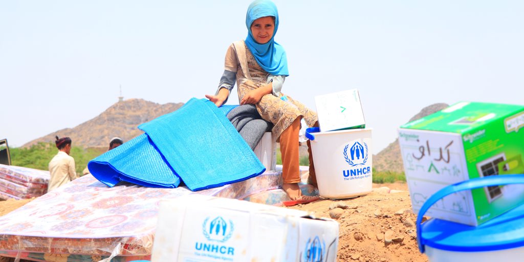 Child with UNHCR supplies. Displaced families in Yemen receive essential household items.