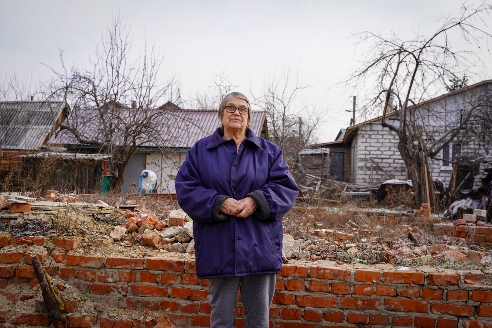 Kateryna stands in the ruins of her home in Chernihiv, Ukraine. It was completely destroyed by a Russian missile strike.