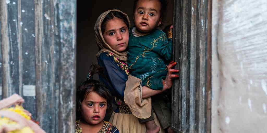 Children look out from the doorway of a new sustainable home, built with UNHCR support, in Nangarhar province, Afghanistan.